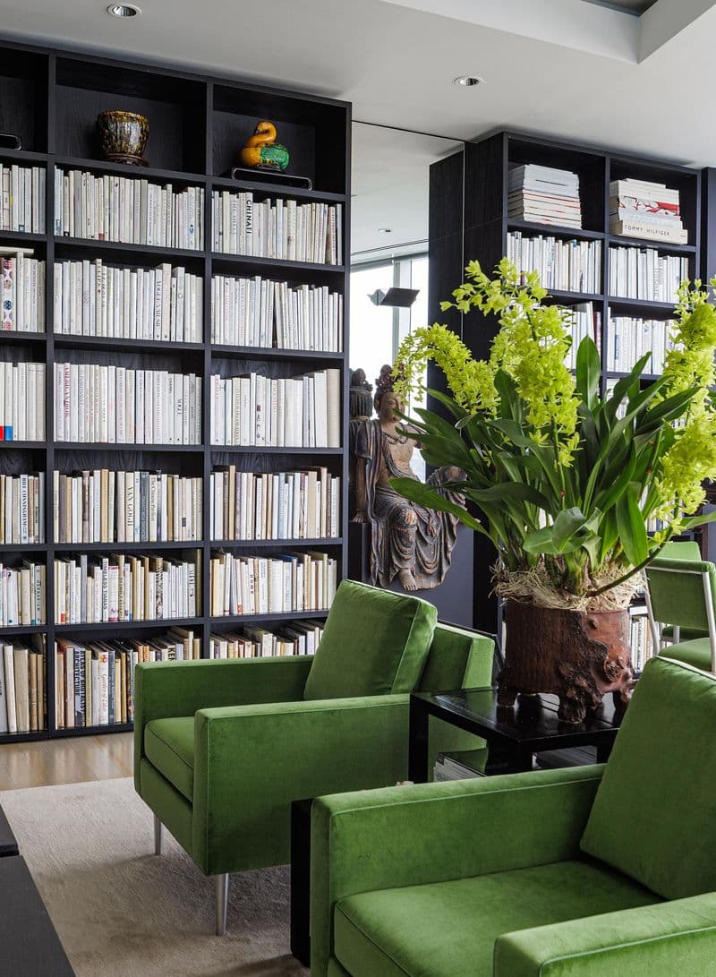 Sala de estar estilo galería con estantes personalizados con acabado negro de California Closets.