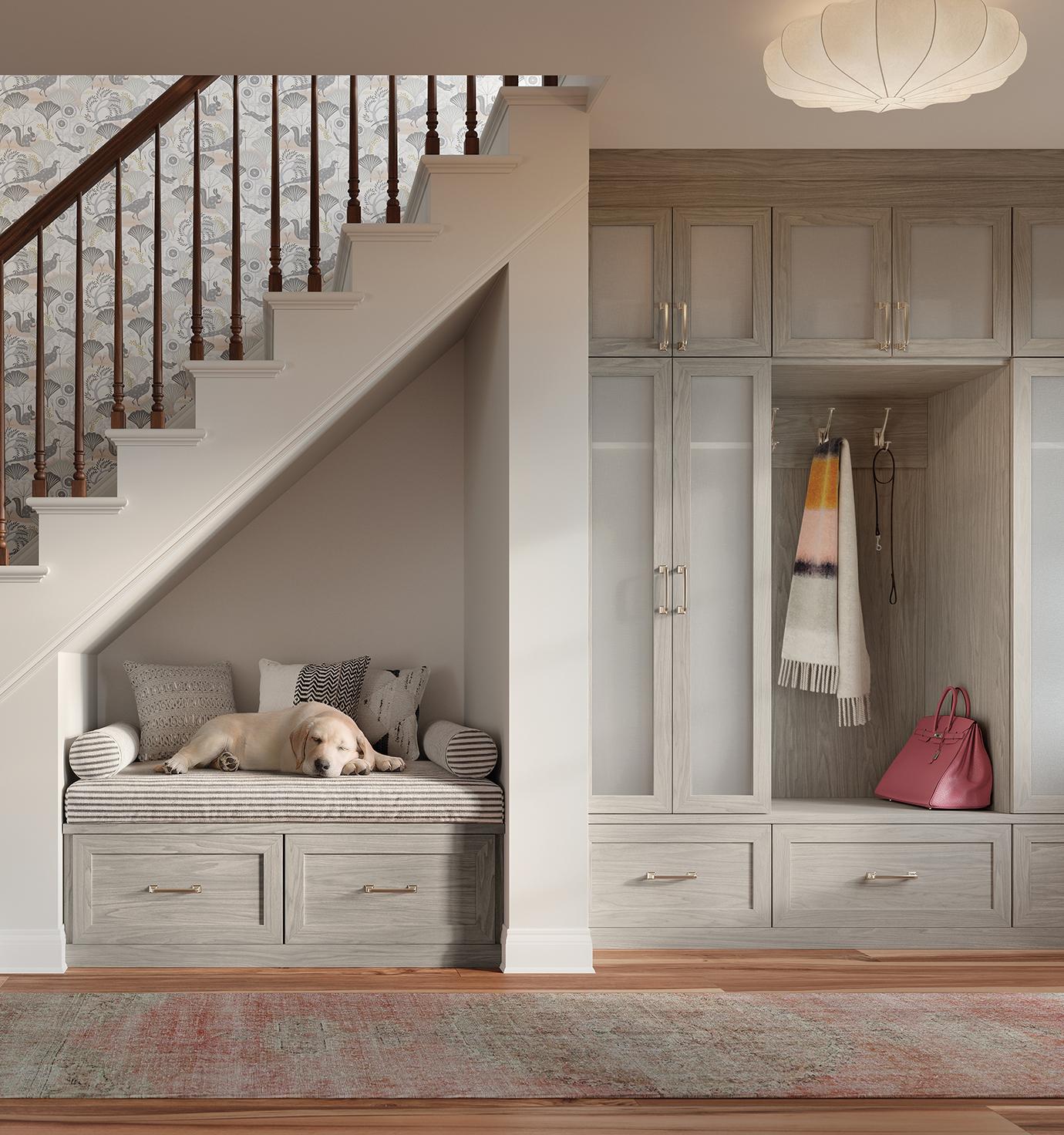 Entrada junto a la escalera con banco, gabinetes de diseño personalizado y cajones con acabado de grano claro de California Closets