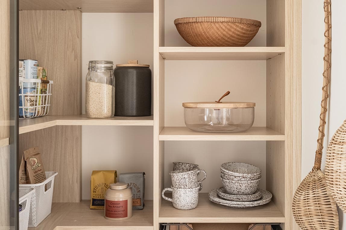 Diseño de despensa de esquina con estantes de esquina y estantes envolventes fabricados por California Closets