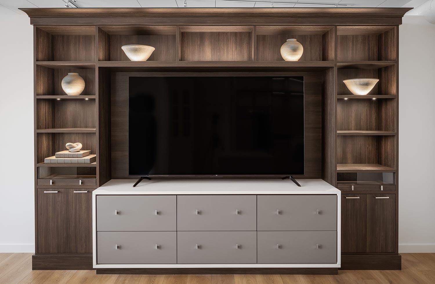 Cajones de almacenamiento blancos personalizados para centro de entretenimiento con acabado en madera oscura de California Closets
