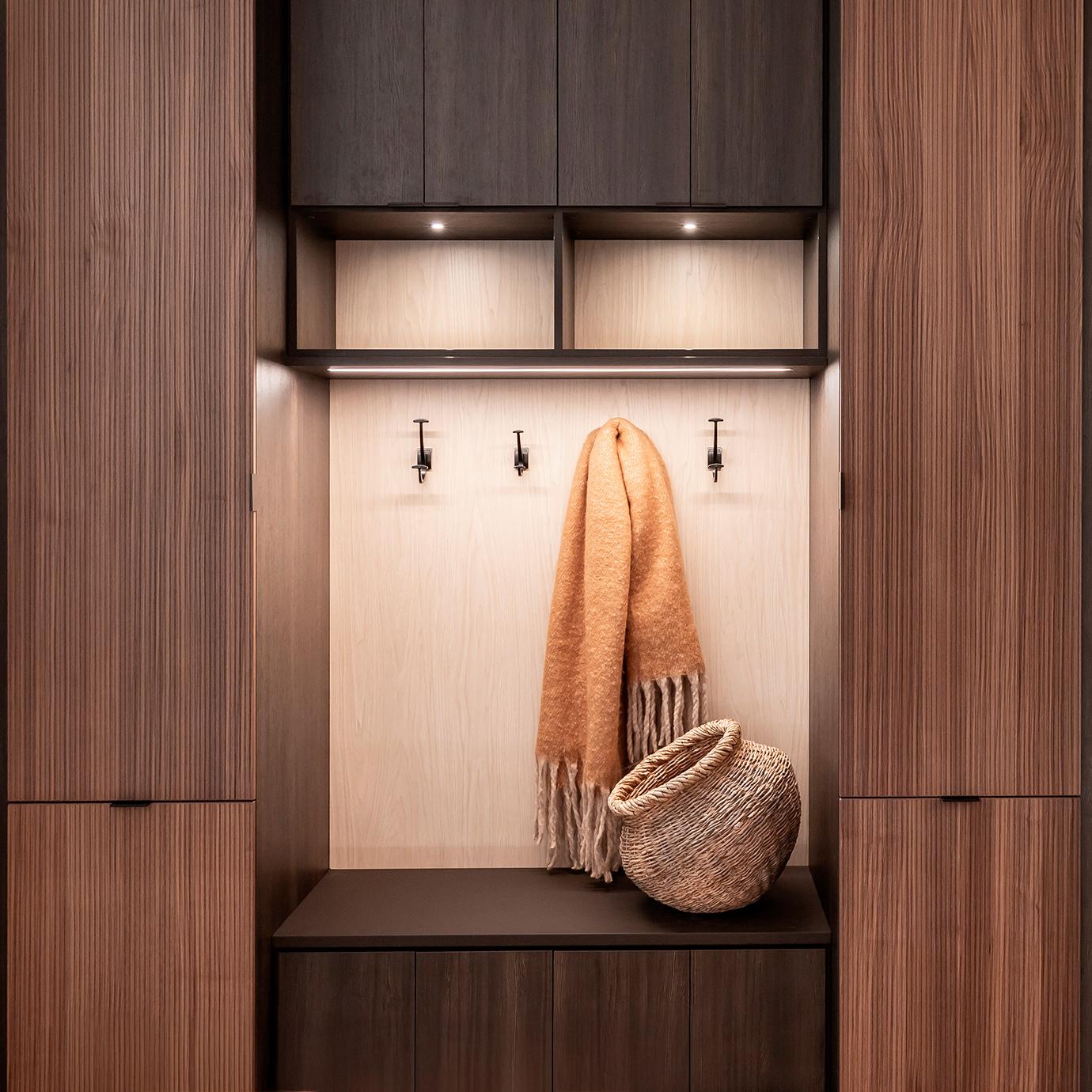 Banco de almacenamiento personalizado para entrada fabricado con un acabado de madera oscura por California Closets