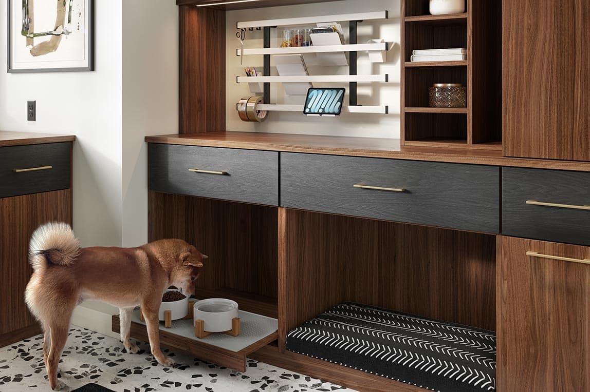 Espacio de almacenamiento personalizado en el vestíbulo con cama para mascotas y estación de alimentación diseñado por California Closets