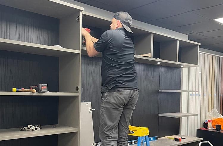 Técnico instalador usando un nivel en una instalación doméstica de California Closets