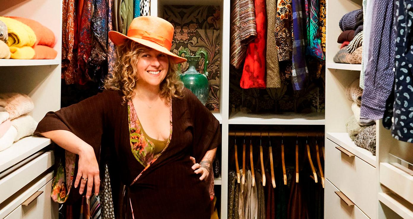 Olga Naiman de pie frente a su clóset tipo walk-in, personalizado con repisas abiertas y cajones de California Closets