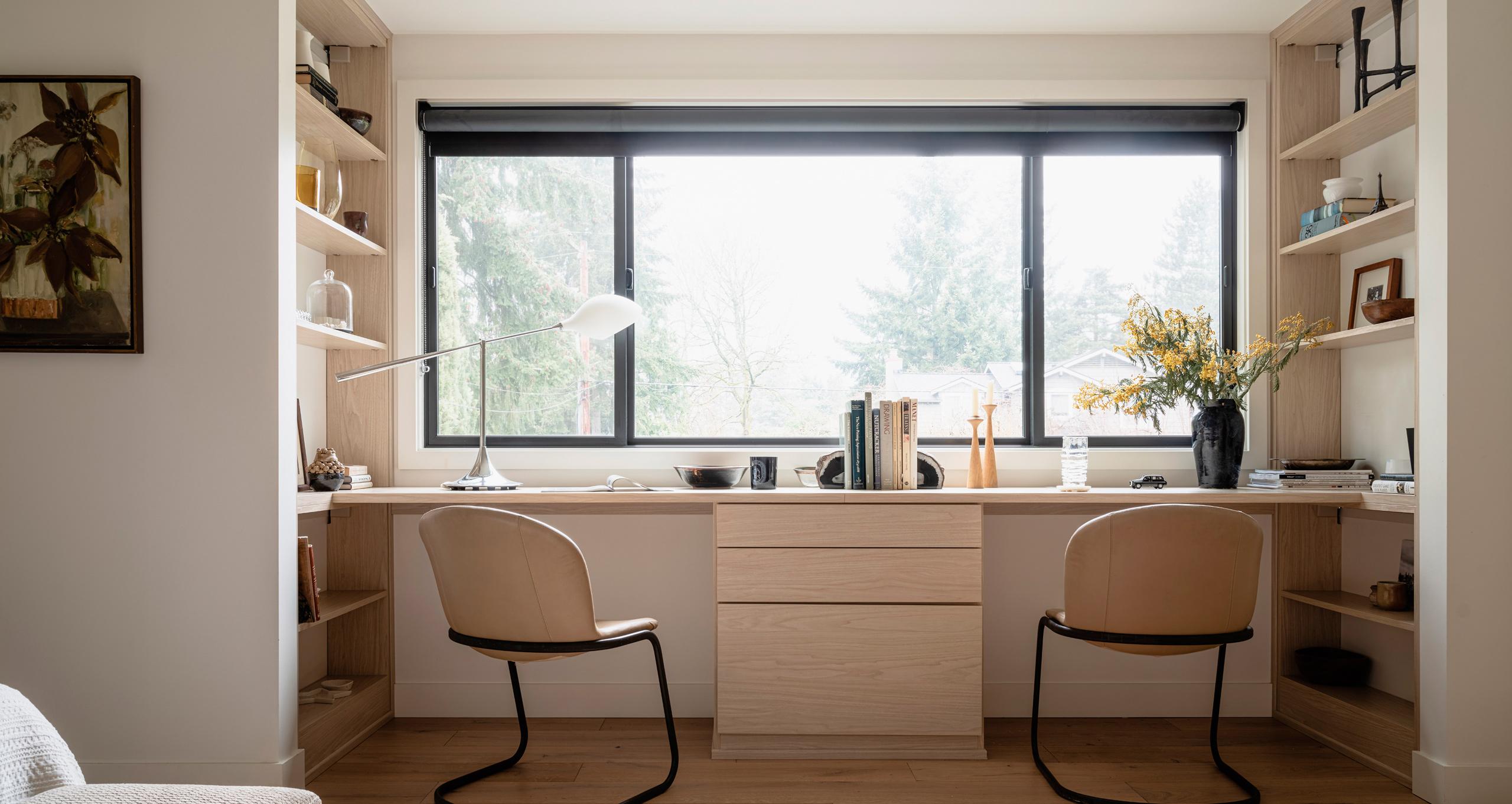 Diseño de oficina en casa compartida que presenta un escritorio de ventana empotrado personalizado con una unidad central de cajones y estanterías a juego de California Closets.