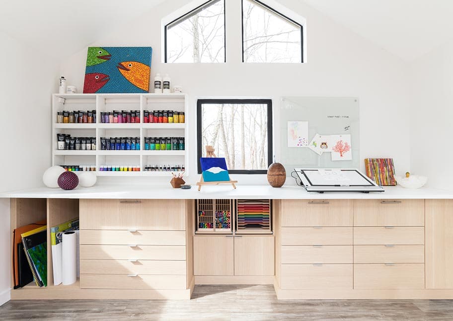 Cuarto de manualidades hecho a medida con un escritorio empotrado y armarios de California Closets
