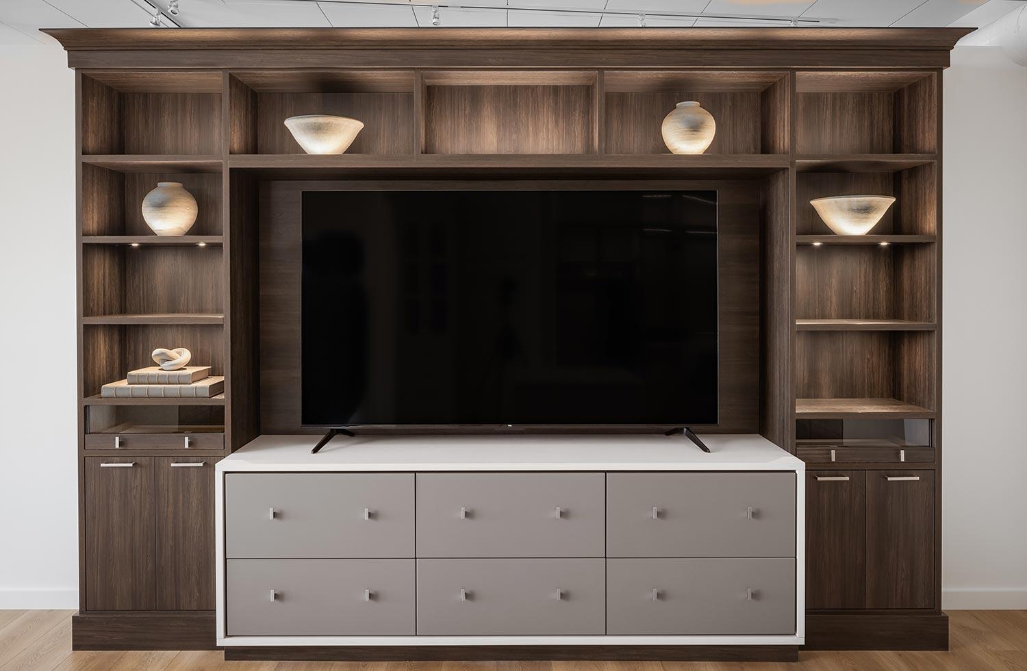 Centro de entretenimiento para el hogar personalizado con almacenamiento de pared, estantes y cajones en acabados claros y oscuros de California Closets