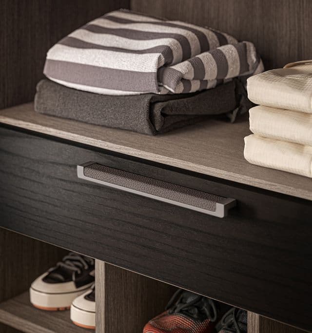 Customized drawers and shoe cubbies in a walk in closet designed by California Closets