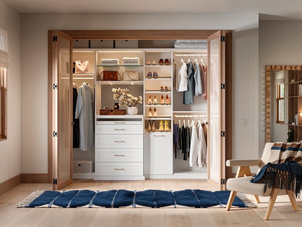 Reach in closet with custom counter, lighting, drawers and hamper by California Closets
