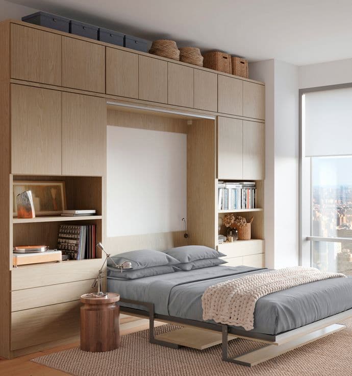 Cama plegable oculta diseñada con gabinetes de almacenamiento personalizados, cajones y estantes abiertos por California Closets