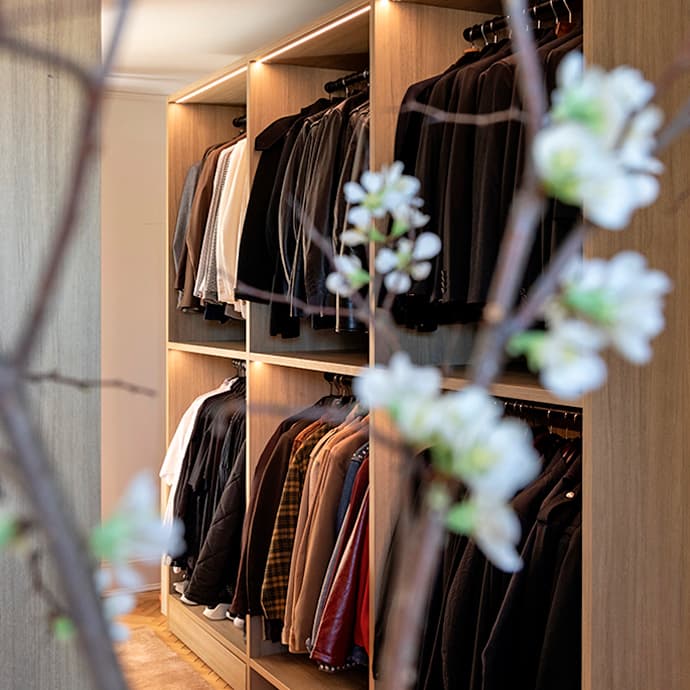 Custom wardrobe design for Jeremiah Brent in natural wood grain finish by California Closets