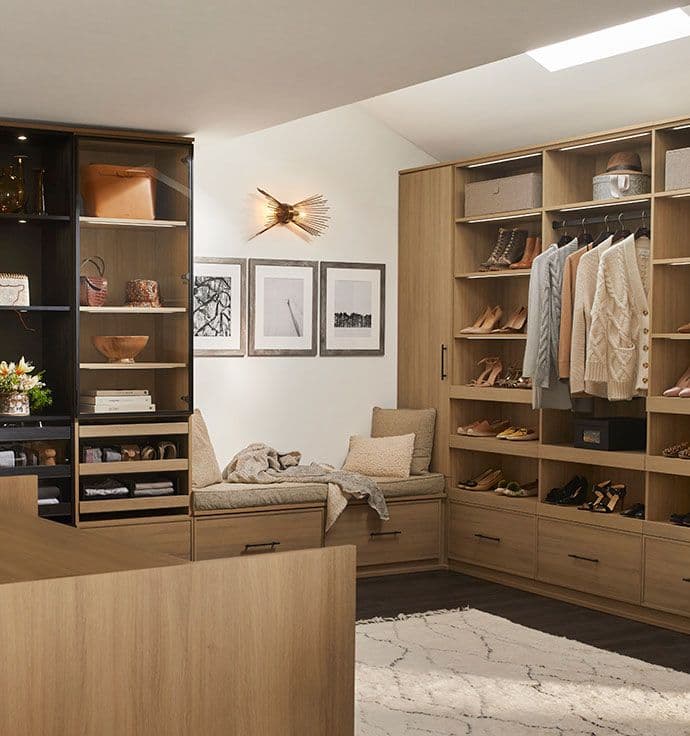 Vestidor personalizado con iluminación LED natural y de cinta, isla, banco con acabado natural de California Closets