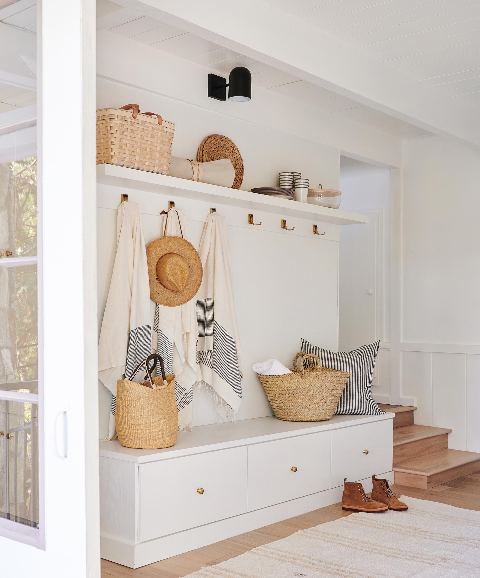 Entryway storage bench, hooks and custom shelves created by California Closets