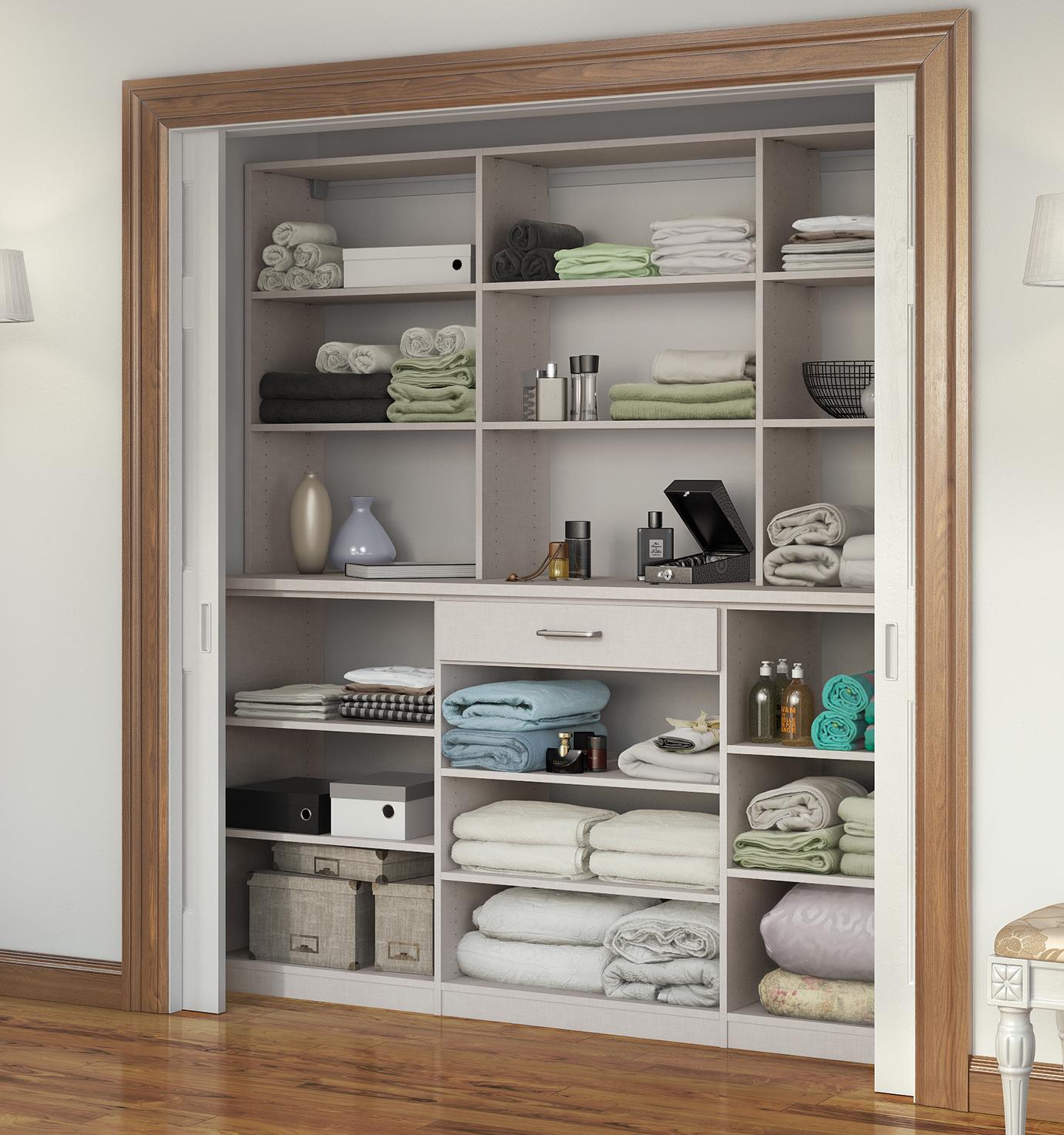 Hallway linen closet shelving with built in drawers in a light wood finish with sliding doors by California Closets